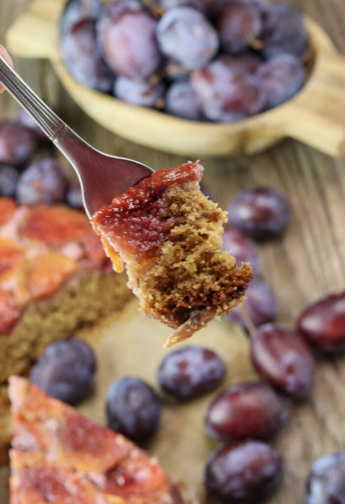 A piece of delicious buckwheat upside down cake loaded on a fork, ready to be eaten.